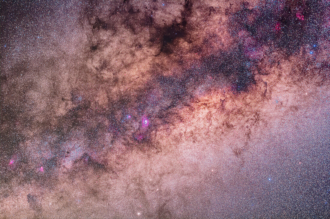 The centre of the galaxy area of the Milky Way toward Sagittarius and Scorpius, with the Sagittarius Starcloud right of centre, and the Lagoon Nebula (M8) left of centre. The Cat's Paw Nebula (NGC 6334) in Scorpius is at upper right, the Swan Nebula (M17) and Eagle Nebula (M16) are at lower left. To the right of them is the Small Sagittarius Starcloud (M24). At the very top is the Snake Nebula (B72). The main mass of dark nebula is the Pipe Nebula (B78). Above M24 at left is the open cluster M23 while below the M24 star cloud is the cluster M25. The globular M22 is at the bottom edge. At right