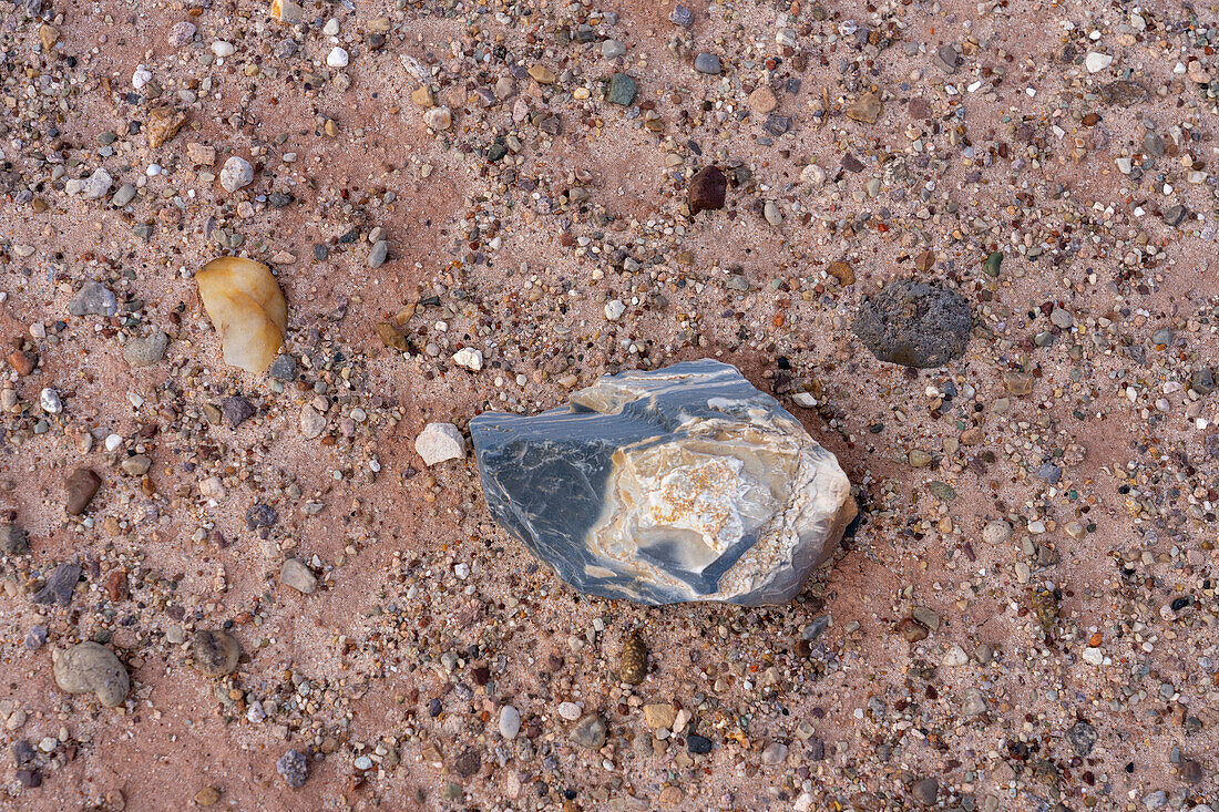 A colorful chert agate stone beside a piece of volcanic basalt in the Morrison Formation of the Caineville Desert, Hanksville, Utah.