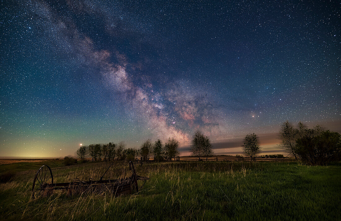 Die späte Frühlingsmilchstraße von meinem ländlichen Hinterhof in Alberta (51° nördlicher Breite) in einer schönen Maiennacht im Jahr 2020, als der zunehmende Mond gerade untergeht und die Landschaft und den Himmel erhellt. Jupiter (am hellsten) und Saturn im Osten (links) gehen gerade gemeinsam links, östlich der Milchstraße, auf. Westlich des galaktischen Zentrums (rechts) befindet sich der rote Antares im Skorpion. In der Mitte sind die Kleinen Sagittarius- und Scutum-Sternwolken mit ihren verschiedenen Messier-Nebeln und Sternhaufen zu sehen.