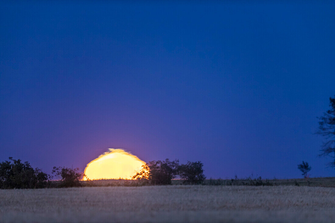 A frame from a time-lapse showing the rising 15-day-old Moon exhibiting the Chinese lantern effect from atmospheric refraction.