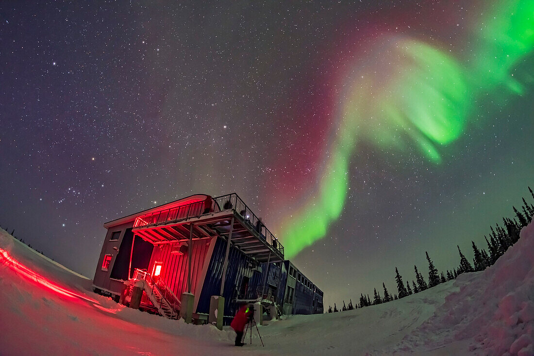 Orion und der Winterhimmel, links, und ein Wirbel aus bunten Polarlichtern über dem Churchill Northern Studies Centre, bei einer Vorführung am 11. Februar 2018. Teilnehmer der ersten Learning Vacations-Gruppe der Saison fotografieren die Lichter.