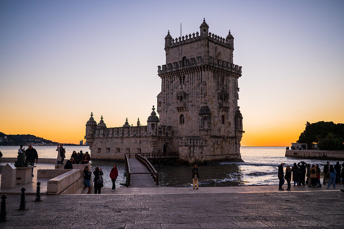 Menschen genießen einen schönen Sonnenuntergang vom Turm von Belem oder Turm von St. Vincent am Ufer des Tejo, Lissabon, Portugal
