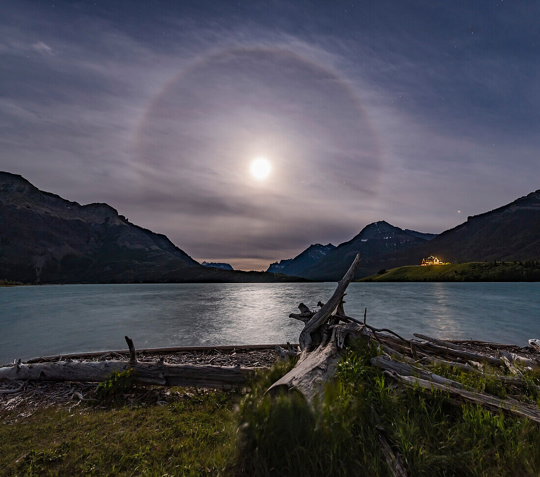 An ice crystal halo around the Full Moon on solstice eve, June 19, 2016, from Driftwood Beach at Waterton Lakes National Park, Alberta. Mars is the bright object at far right, Saturn is just right of the Moon. The iconic Prince of Wales Hotel is below Mars.