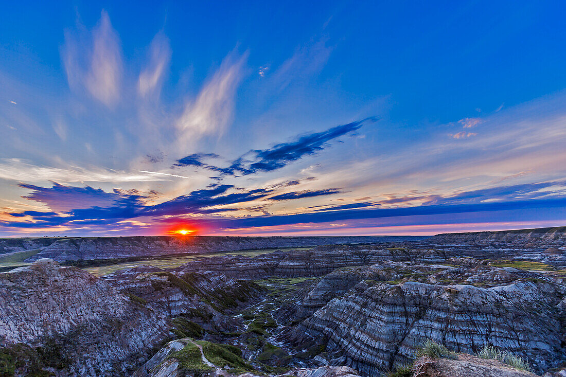 Sonnenuntergang am 1. August 2015 am Horsethief Canyon Viewpoint mit Blick auf den Red Deer River, nördlich von Drumheller, Alberta, auf dem Dinosaur Trail scenic drive. Der Name stammt aus der Pionierzeit, als sich die Pferde hier in den Badlands verirrten und dann wieder auftauchten, allerdings mit einem neuen Brandzeichen. Die Region beherbergt reiche Vorkommen an Dinosaurierfossilien aus der späten Kreidezeit. Etwas südlich von hier befindet sich das Royal Tyrrell Museum, ein Forschungszentrum für Dinosaurier und prähistorisches Leben von Weltrang.