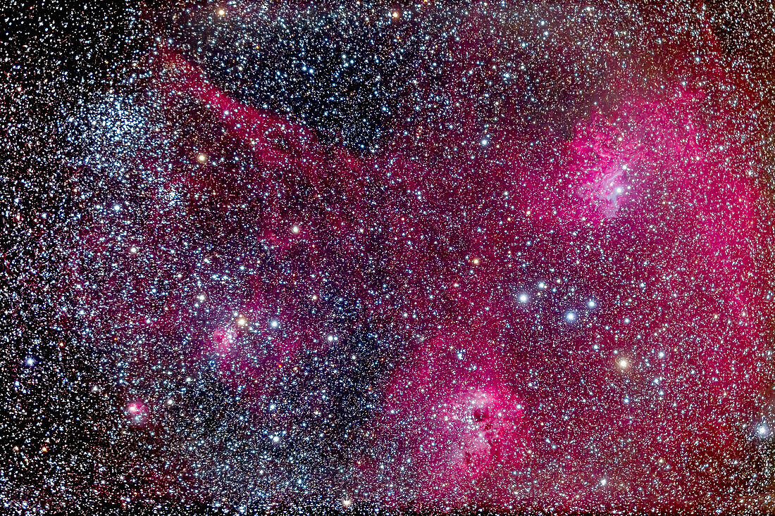 The complex area of clusters and nebulosity in central Auriga, including: M38 the Starfish Cluster and its smaller companion cluster NGC 1907; the emission/reflection nebulas NGC 1931, IC 417, IC 410 and IC 405 (from right to left here). Magenta and cyan (from emission and reflection components) IC 405 at right is the Flaming Star Nebula. Between IC 405 and IC 410 is the asterism known as The Little Fish.