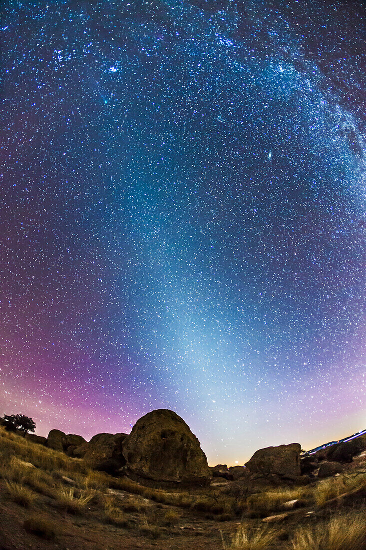 A scene looking west on January 16, 2015 but with a field stretching up to and beyond the zenith overhead, taking in the Zodiacal Light stretching up to the Pleiades at upper left. Just below the Pleiades is green Comet Lovejoy, with its faint ion tail pointing away from the Sun along the same plane as the Zodiacal Light, as it should. Ion tails always point directly away from the Sun, as they are blown out by the solar wind. Comet Lovejoy was crossing the ecliptic this night, as it heads north in its orbit traveling almost perpendicular to the ecliptic plane.