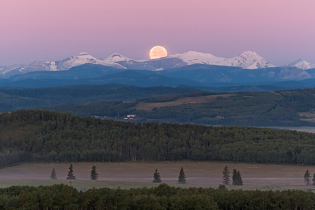 ull Moon setting over Rocky Mountains, taken from Rothney Astrophysical Observatory on August 28, 2007, night of total eclipse of the Moon. Umbral eclipse was over by moonset though the Moon was still in penumbral eclipse. Taken with Canon 20Da camera and 135mm lens at ISO800 and f/4.5 for 1/160 sec. Moon in blue of Earth's shadow on atmosphere.