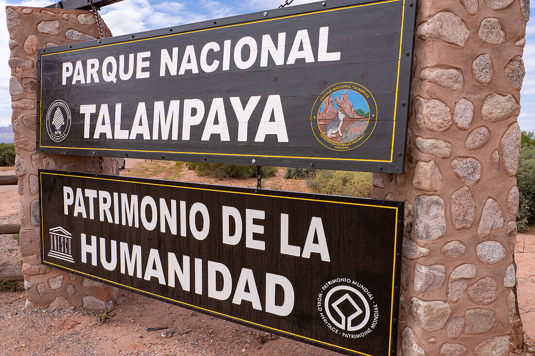 Park sign for Talampaya National Park, La Rioja Province, Argentina. Behind is the Sierra de Sanogasta mountain range.