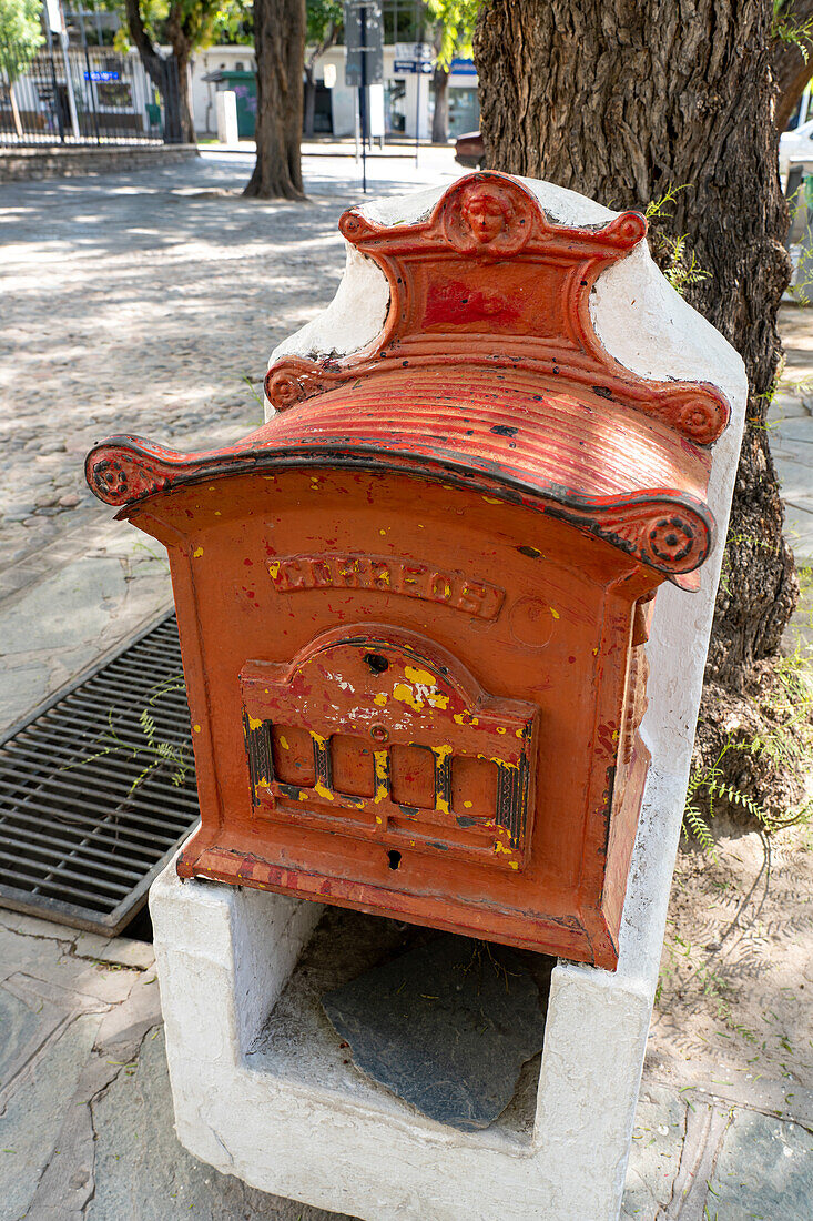 An antique metal post box in front of the Birthplace Museum of Domingo F. Sarmiento in San Juan, Argentina.