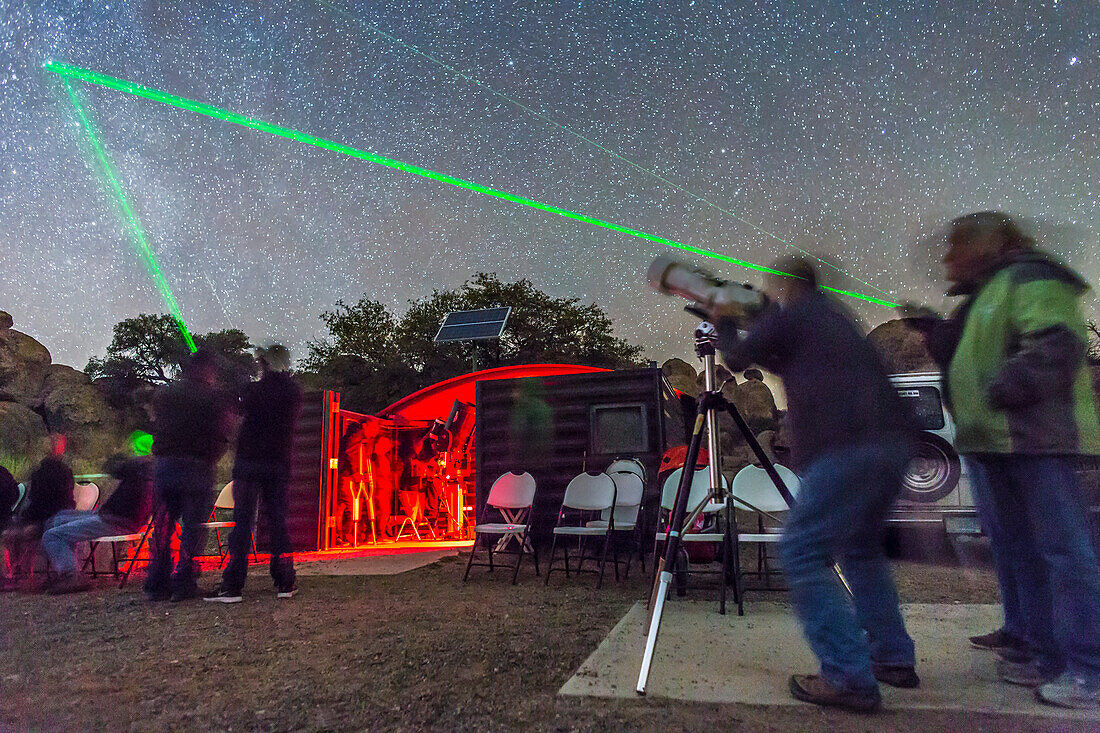 Eine Szene bei der öffentlichen "Parks 'n Stars"-Sternbeobachtungsnacht am 15. März 2015 im City of Rocks State Park, New Mexico, und im Gene und Elizabeth Simons Observatorium auf dem Orion-Gruppencampingplatz. Hier zielen die Beobachter mit ihren Laserpointern auf die Position des Kometen Lovejoy in der Kassiopeia, der oben links gerade noch sichtbar ist. Die Beobachter verwenden die großen Ferngläser, um den Kometen zu beobachten.