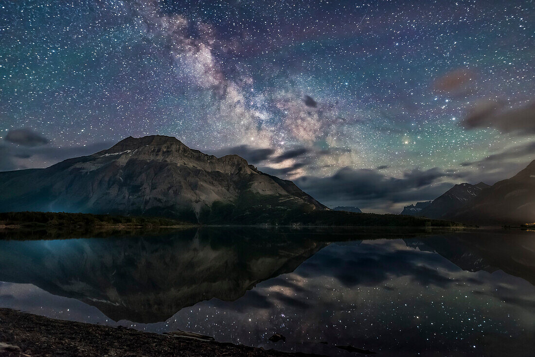 The Milky Way reflected in the unusually calm waters of Middle Waterton Lake from Driftwood Beach, in Waterton Lakes National Park, Alberta, Canada. The Park is an International Dark Sky Preserve, along with Glacier National Park in the U.S. The Park is also a U.N. World Heritage Site.