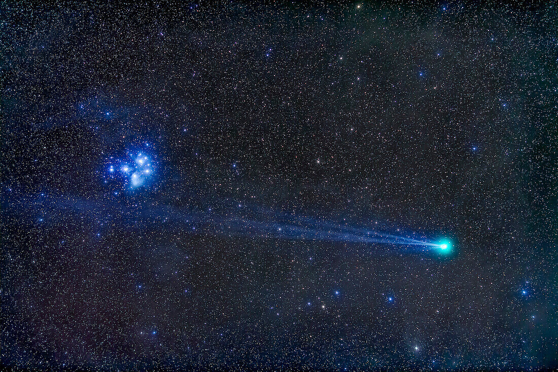Comey Lovejoy, C/2014 Q2, nearest the Pleiades star cluster, Messier 45, on the night of Sunday, January 18, 2015, with its blue ion tail almost passing over the cluster. This is a stack of 6 x 2 minute exposures at f/2.5 with the 135mm lens and Canon 5D MkII at ISO 1600, on the Sky-Watcher Star Adventurer tracker. Taken from City of Rocks State Park, New Mexico, Some haze was passing thru this night but this is a stack of the cleanest frames.