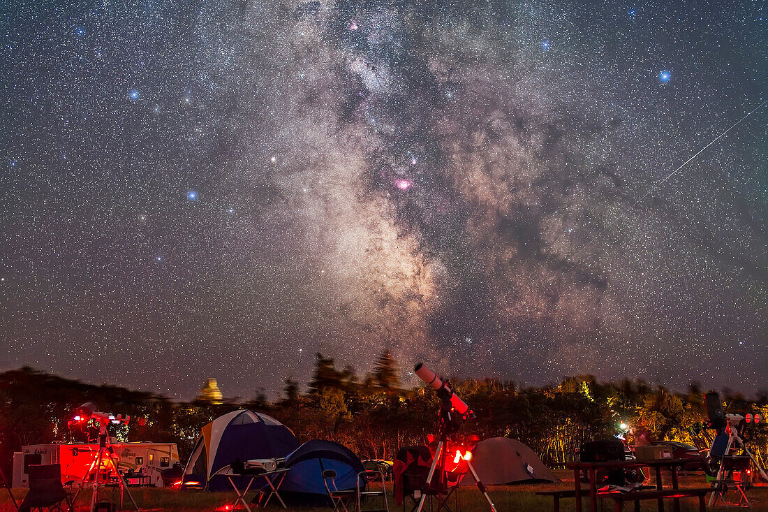 Das Gebiet der Sagittarius-Milchstraße, um das Zentrum der Galaxie, über den Bäumen und dem Campingplatz im Cypress Hills Interprovincial Park, Sasksatchewan. Aufgenommen am 17. August 2012 während der Saskatchewan Summer Star Party. Dies ist eine Zusammenstellung von 6 Belichtungen: alle 2 Minuten bei f/2.8 und ISO 1600 mit der Canon 5D MkII und dem Sigma 50mm Objektiv, aber 5 Belichtungen wurden nachgeführt und 1 Belichtung wurde nicht nachgeführt, um zu verhindern, dass der Boden verschwimmt. Der Boden stammt aus der nicht nachverfolgten Belichtung, der Himmel aus dem Stapel der 5 nachverfo