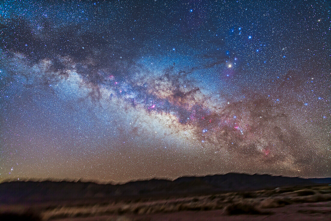 Das Zentrum der Galaxie in Sagittarius und Scorpius, die sich über dem südöstlichen Horizont erheben, von New Mexico aus, im Painted Pony Resort. Dies ist ein Stapel von 5 x 5-Minuten-Belichtungen mit dem 24mm-Objektiv bei f/2.8 und der Canon 5D MkII bei ISO 800. Die Landschaft wurde mit einer Belichtung aufgenommen und die Schattendetails hervorgehoben. Ein zusätzliches Bild, das durch den Kenko Softon-Filter aufgenommen wurde, wurde überlagert, um das Sternenglühen hinzuzufügen.