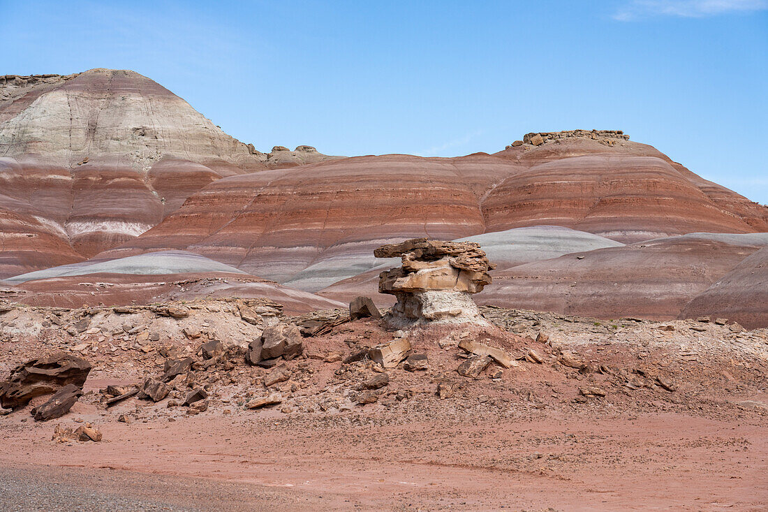 Ein Sandsteinfelsen auf einem Lehm-Hoodoo in den Bentonit-Hügeln der Caineville-Wüste bei Hanksville, Utah.