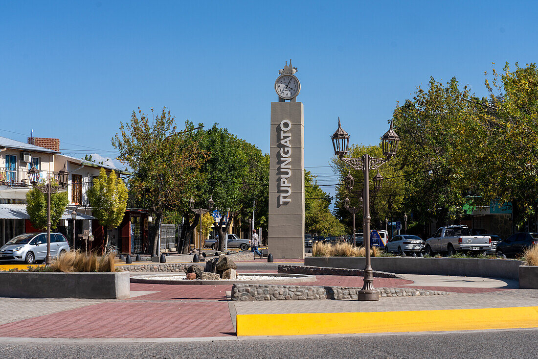 Ein Uhrenturm und ein Schild in einem Kreisverkehr in der Weinstadt Tupungato im Valle de Uco in der Provinz Mendoza, Argentinien.
