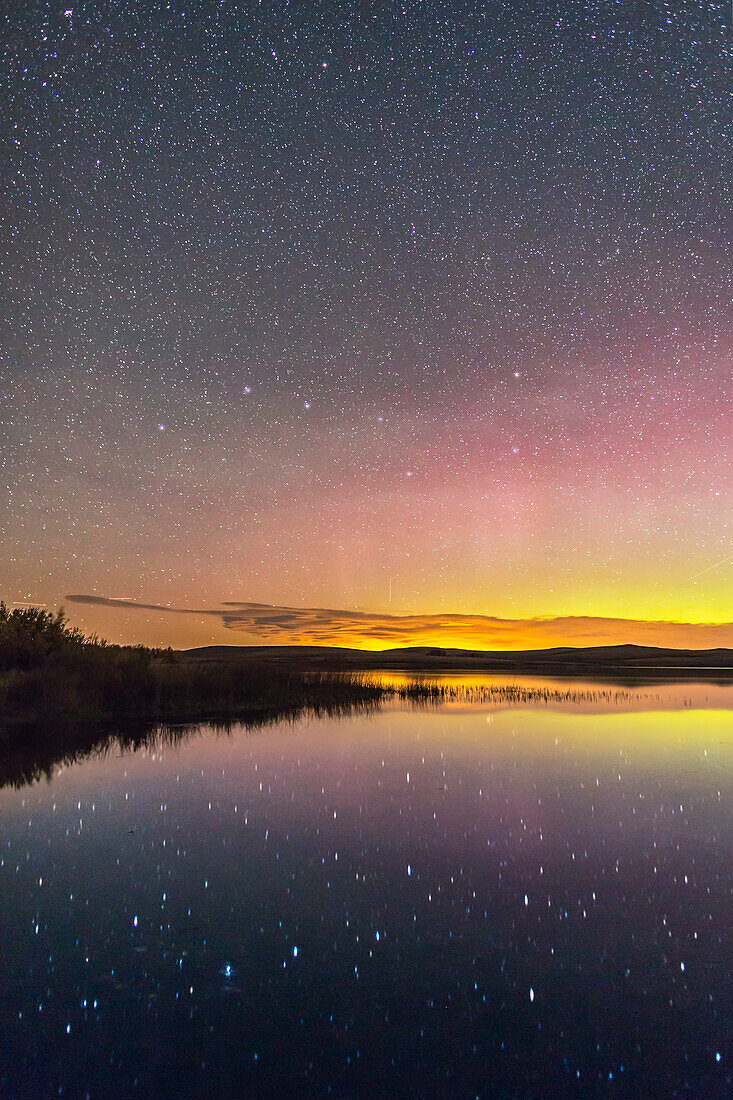 The Big Dipper reflected in the still waters of the lake at Police Outpost Provincial Park, in southern Alberta, on September 26, 2016, with an aurora to the north at right. Only in autumn can one shoot the Dipper reflected in the water in the evening sky, as it is then riding low along the northern horizon. This is from a latitude of 49° N where the Dipper is circumpolar. It is also called the Plough in Great Britain.