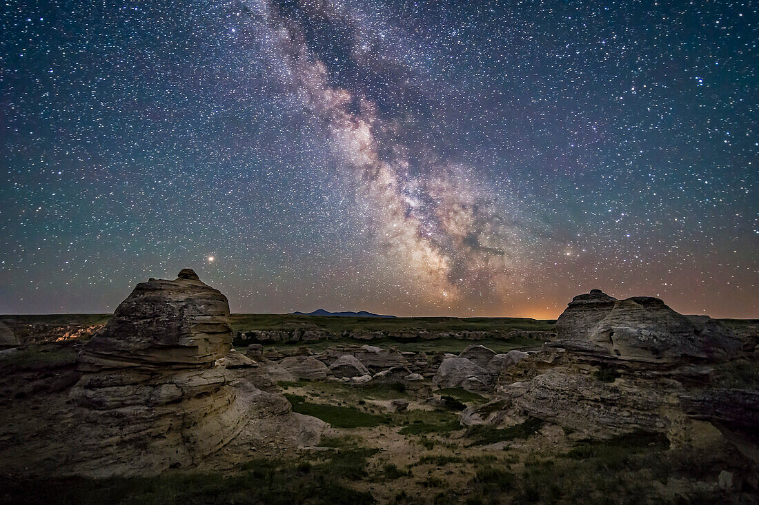 Mars (at left) and the galactic centre area of the summer Milky Way low over the southern horizon at Writing-on-Stone Provincial Park, Alberta, on June 8/9, 2018. Sagittarus is at centre, with Scorpius at right. The Messier 6 and 7 open star clusters are just above the horizon at centre, just right of the Sweetgrass Hills on the horizon in Montana.
