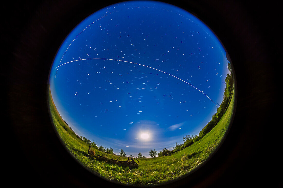 An overhead pass of the International Space Station in a bright moonlit sky on the night of May 31/ June 1, 2015, with the gibbous Moon in to the south, below. The view is looking south, with the ISS travelling from right (west) to left (east) over several minutes. This was the second pass of a 4-pass night, May 31/June 1, starting at 12:44 am MDT this morning.