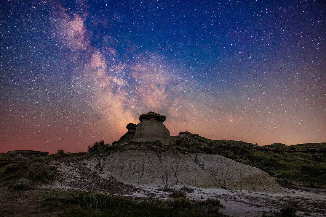 Das galaktische Zentrum in Sagittarius (links) und Scorpius (rechts) tief im Süden in einer Sommernacht im Dinosaur Provincial Park, Alberta. Das war am 30. Juni/1. Juli 2022. Da es nur 10 Tage nach der Sommersonnenwende war und wir uns auf +50° nördlicher Breite befanden, hatte der Himmel selbst im Süden noch einen blauen Schimmer von der nächtlichen Dämmerung. Ich habe keinen Versuch unternommen, die Himmelsfärbung zu neutralisieren. Darüber hinaus verfärbte etwas Dunst vom Rauch den Himmel und verringerte die Transparenz und den Kontrast in den tiefen Lagen des Himmels.