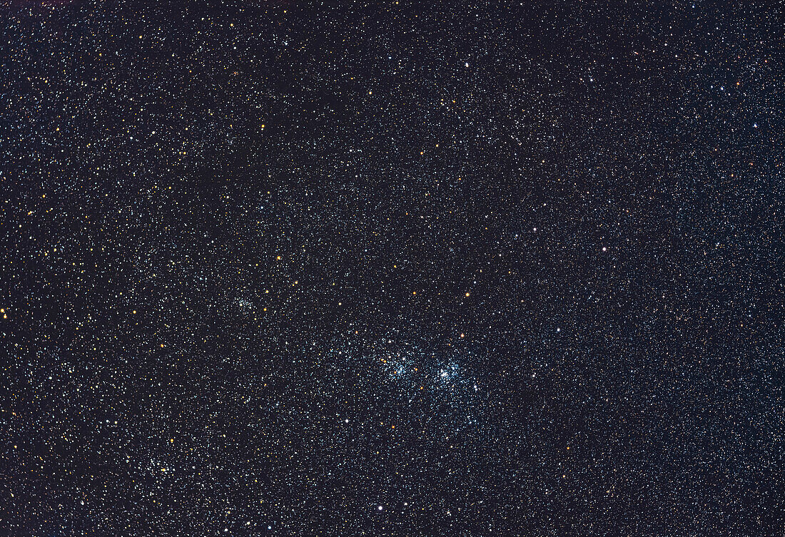 The famous Double Cluster (NGC 869, right and NGC 884, left) in Perseus, in a wide-field shot that includes the nearby stars clusters NGC 957 to the left, and Trumpler 2 at bottom left. The large and sparse cluster Stock 2, aka the Muscle Man Cluster, is at upper right. The field is filled with yellow supergiant stars. The field of view is similar to that of binoculars.