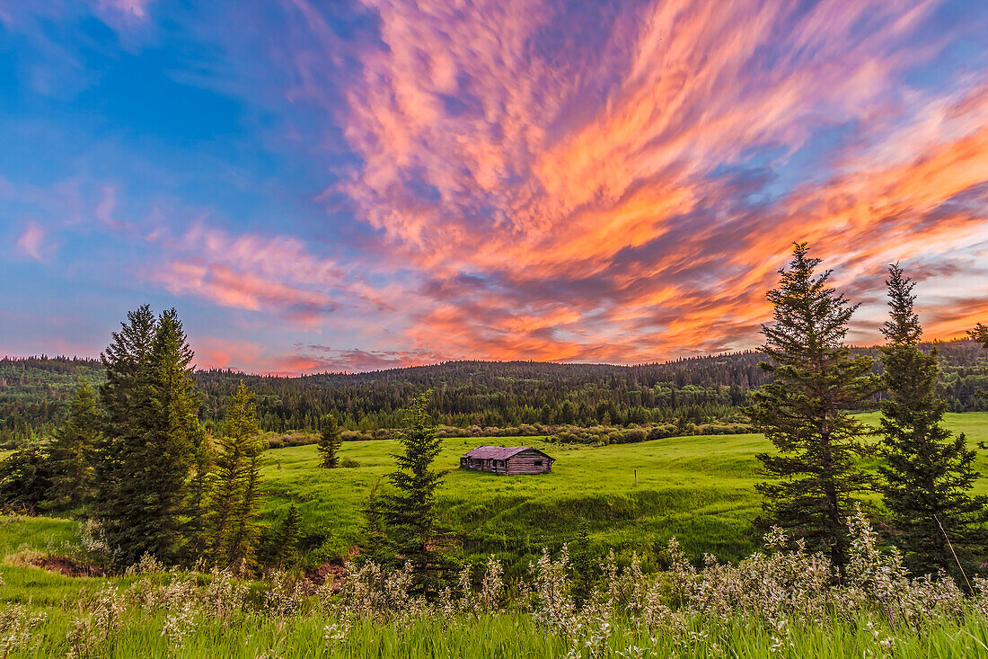 Die Symons-Noble-Blockhütte aus den 1940er Jahren im Cypress Hills Interprovincial Park, auf der Seite von Saskatchewan, bei Sonnenuntergang am 9. Juli 2014. Dies ist ein Stapel von 6 Bildern für eine Komposition mit hohem Dynamikbereich, um den hellen Himmel und den dunkleren Vordergrund in einem Bild zu erfassen. Aufgenommen mit der Canon 60Da und dem 10-22mm Objektiv.