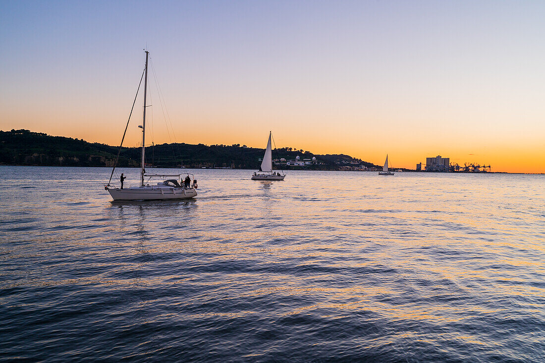 Segelboote bei Sonnenuntergang im Fluss Tejo, Belem, Lissabon, Portugal