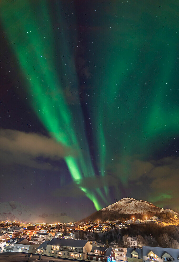 Die Nordlichter über dem Dorf Skjervøy an der Nordküste Norwegens nördlich von Tromsø. Aufgenommen vom Deck des Hurtigruten-Schiffs ms Trollfjord während des Hafenaufenthalts am 2. März 2019. Blick nach Westen mit Kassiopeia rechts und den Plejaden links.