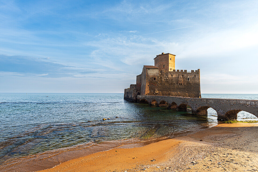 Die Burg Torre Astura erhebt sich über dem Wasser des Tyrrhenischen Meeres vom goldenen Strand aus gesehen bei Sonnenuntergang, Provinz Rom, Latium (Lazio), Italien, Europa