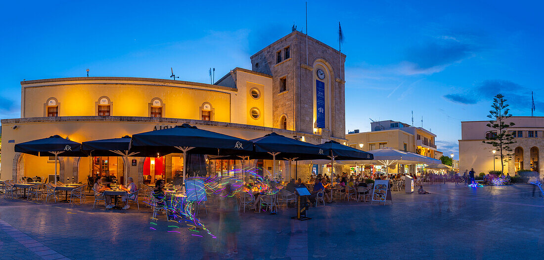 View of cafe and restaurant in Eleftherias Central Square in Kos Town at dusk, Kos, Dodecanese, Greek Islands, Greece, Europe