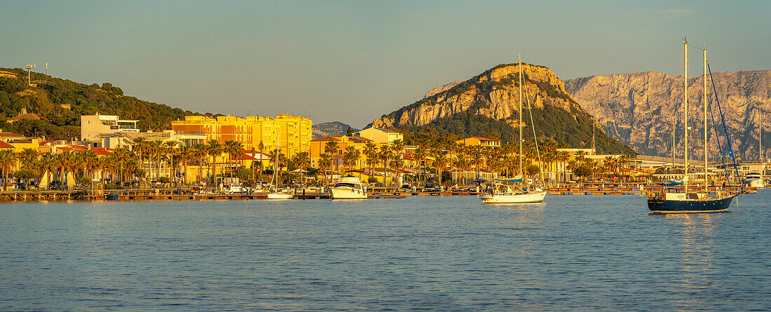 Blick auf Boote und bunte Gebäude bei Sonnenuntergang in Golfo Aranci, Sardinien, Italien, Mittelmeer, Europa