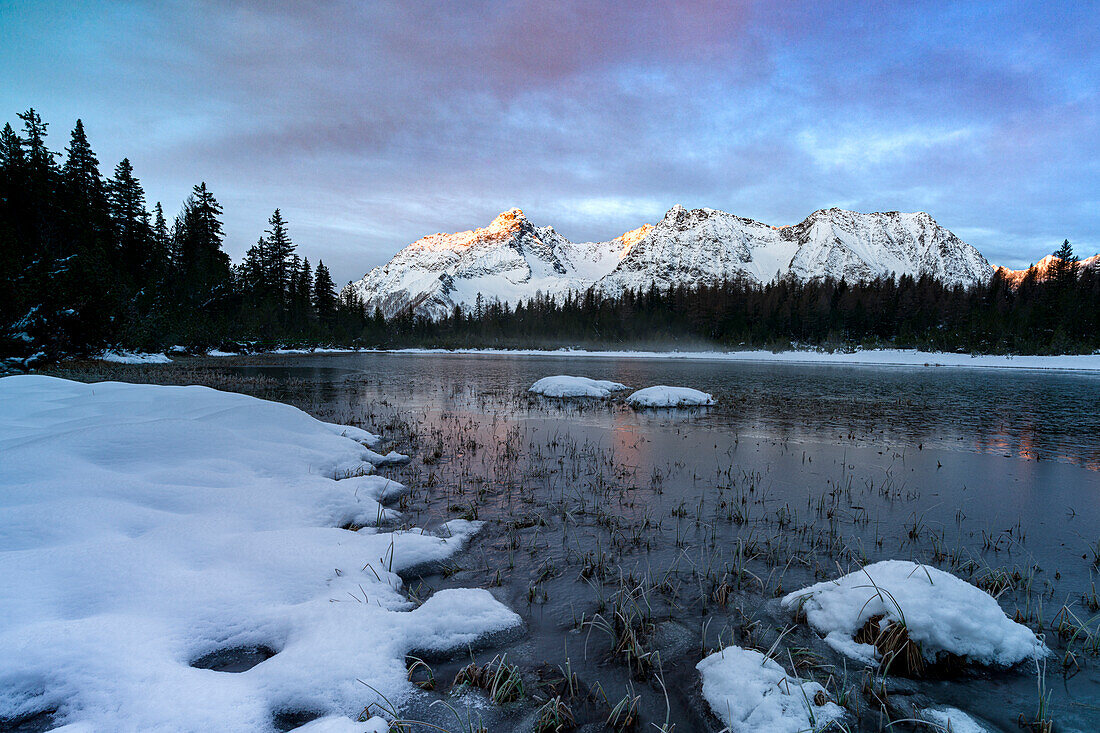 Snowy mountains surrounding the frozen lake Entova, Valmalenco, Valtellina, Lombardy, Italy, Europe