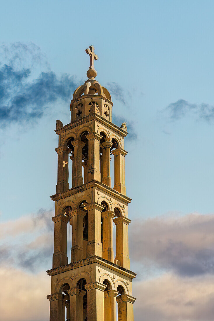 Glockenturm und Kreuz der heiligen orthodoxen Metropolitankirche St. Georg vor einem wolkenverhangenen Himmel in Nafplion, Peloponnes, Griechenland, Europa