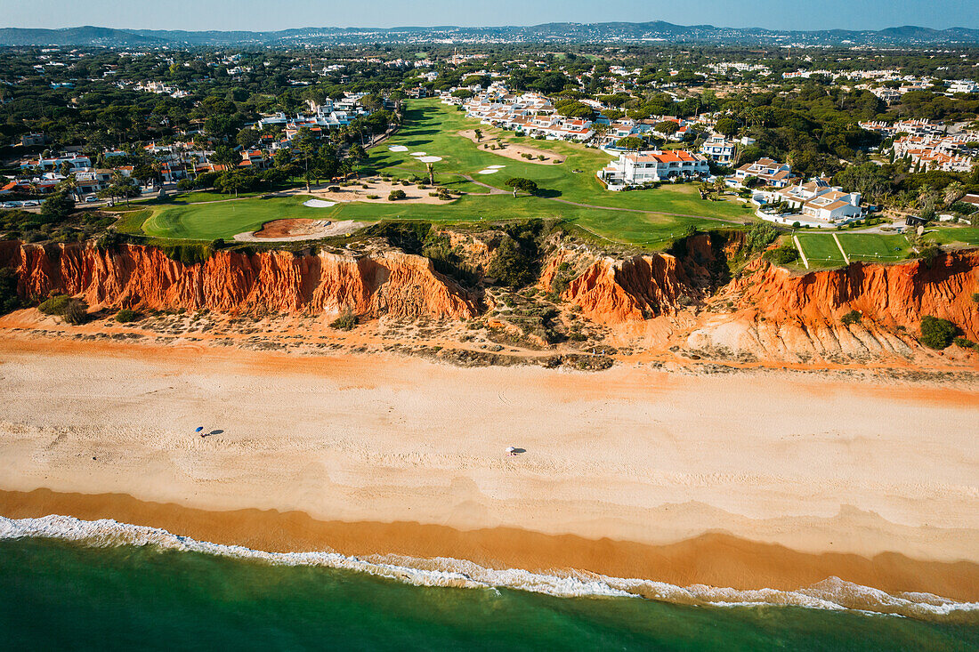 Luftaufnahme von Praia de Vale do Lobo mit herrlichen Golfplätzen mit Blick auf den Ozean an der Algarve, Portugal, Europa