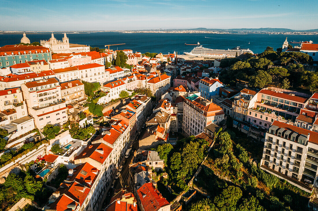 Aerial drone view of Miradouro da Graca with National Pantheon visible on far left, and large cruise ship moored on the Tagus River harbour, Lisbon, Portugal, Europe