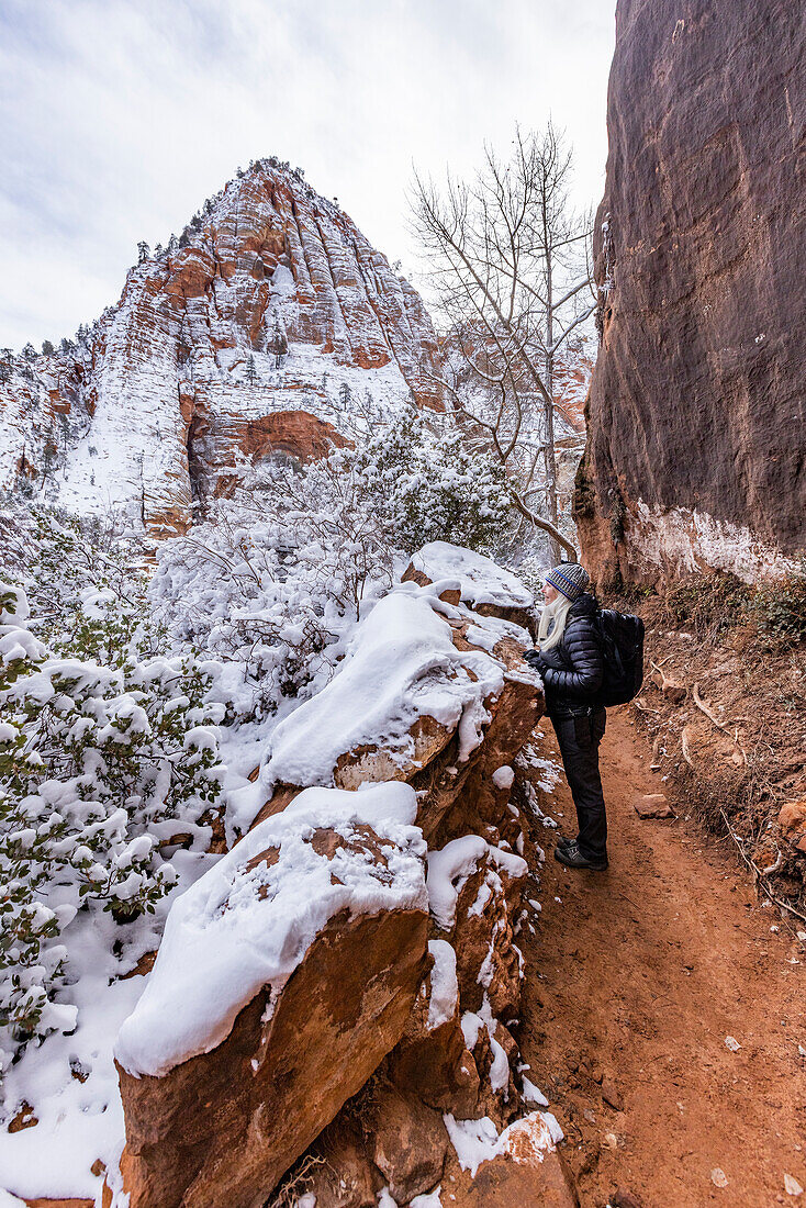 USA, Utah, Springdale, Zion National Park, Senior woman hiking in mountains in winter
