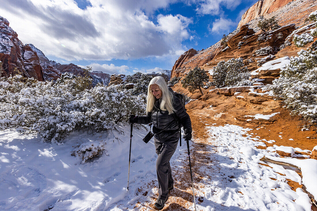 USA, Utah, Springdale, Zion National Park, Senior woman hiking in mountains in winter
