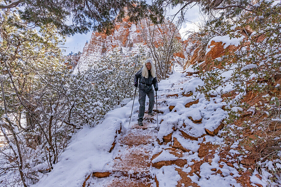 USA, Utah, Springdale, Zion National Park, Senior woman hiking in mountains in winter