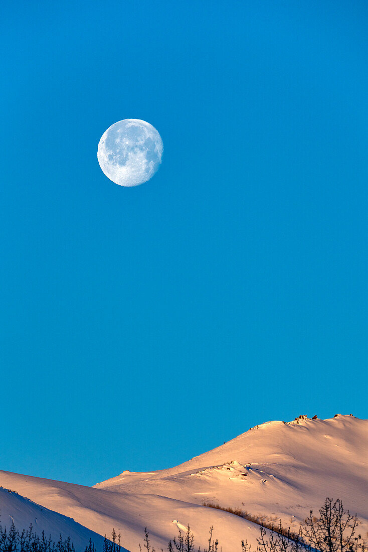 USA, Idaho, Sun Valley, Vollmond über schneebedeckten Hügeln