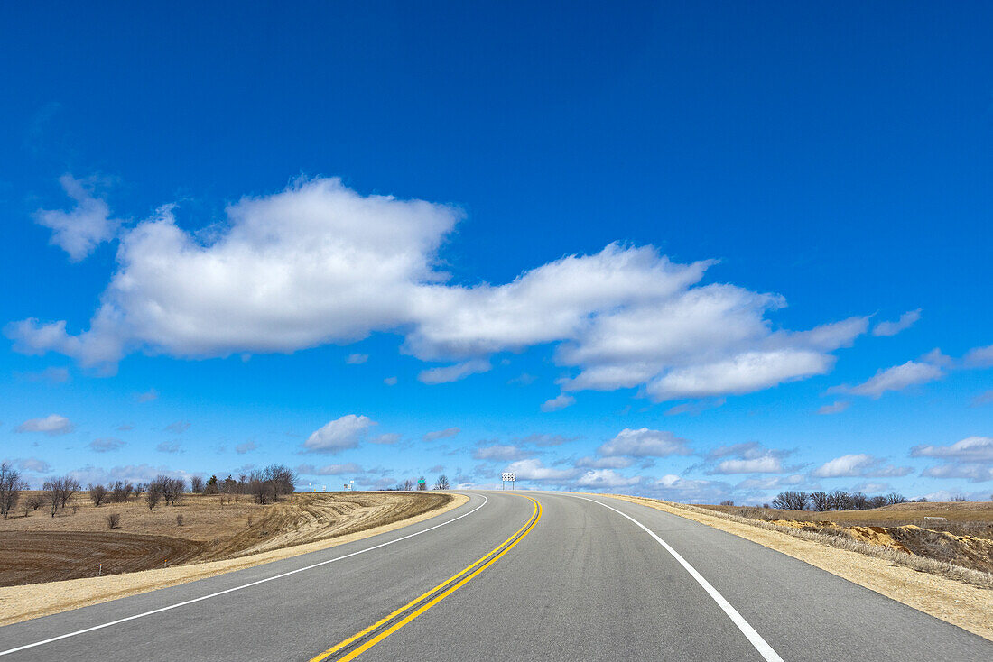 USA, Wisconsin, Madison, leere Landstraße mit blauem Himmel und Wolken