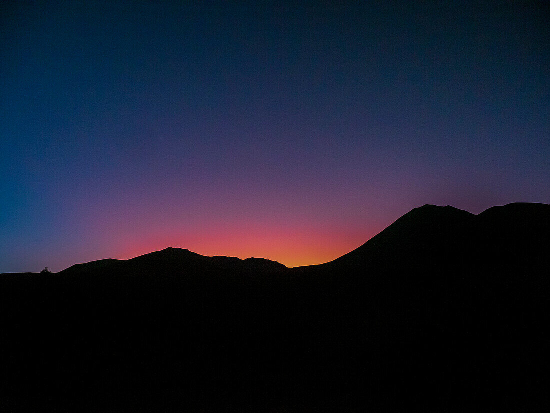 Neuseeland, Waikato, Tongariro National Park, Silhouette eines Bergrückens bei Sonnenuntergang