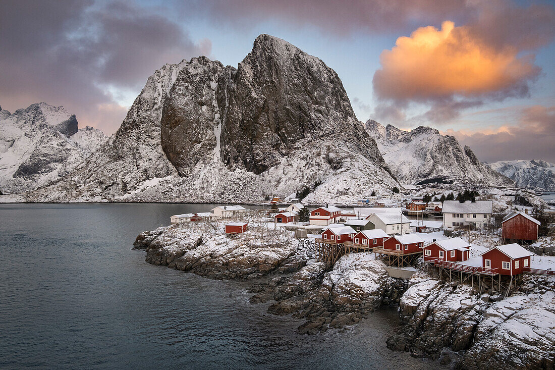 Rote norwegische Rorbuerhütten und der Berg Festhaeltinden im Winter, Hamnoy, Gemeinde Moskenes, Landkreis Nordland, Lofoten, Norwegen, Skandinavien, Europa