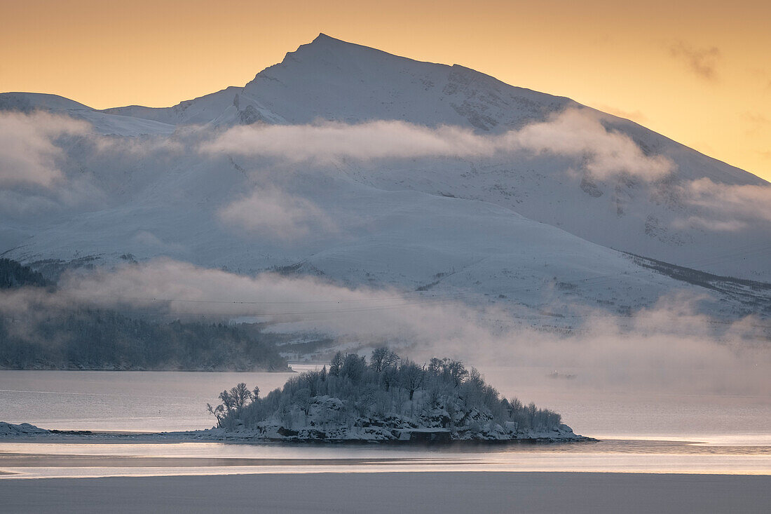 Holman Island in Ramfjorden backed by the peak of Haugafjellet mountain at sunset, near Tromso, Troms og Finnmark county, Norway, Scandinavia, Europe