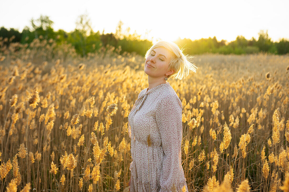 Porträt einer Frau im Feld bei Sonnenuntergang