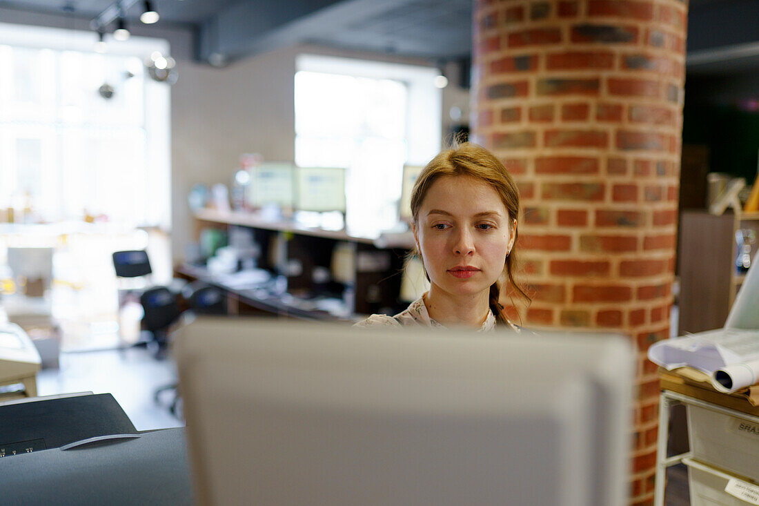 Fokussierte Frau bei der Arbeit in einer Druckerei
