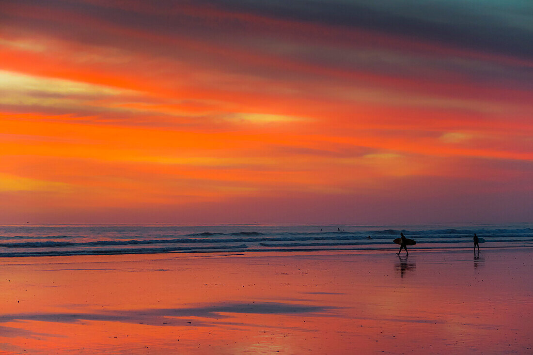 Surfer als Silhouette am Guiones Strand, wo viele zum Sonnenuntergang zum Surfen und Entspannen kommen, Playa Guiones, Nosara, Guanacaste, Costa Rica, Mittelamerika