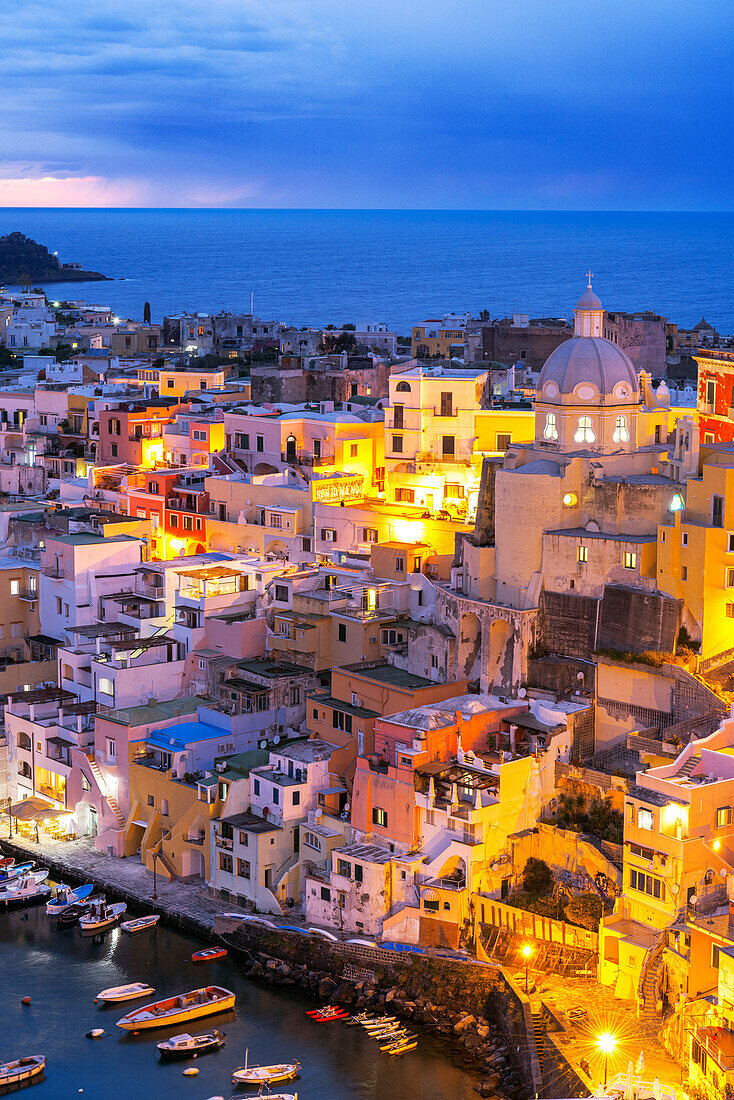 Beleuchtetes Fischerdorf Marina Corricella in der Abenddämmerung, Insel Procida, Tyrrhenisches Meer, Bezirk Neapel, Bucht von Neapel, Region Kampanien, Italien, Europa