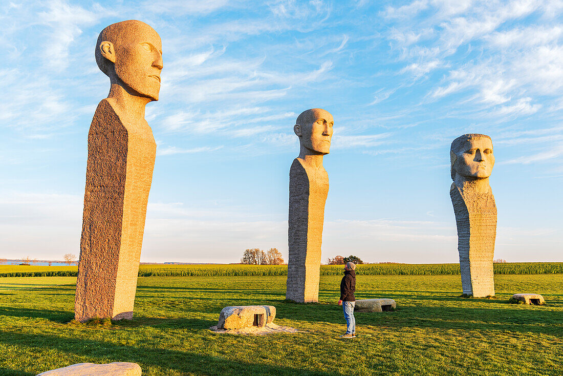 Tourist bewundert Dodekalitten-Statuen bei Sonnenuntergang, Insel Lolland, Region Seeland, Dänemark, Europa
