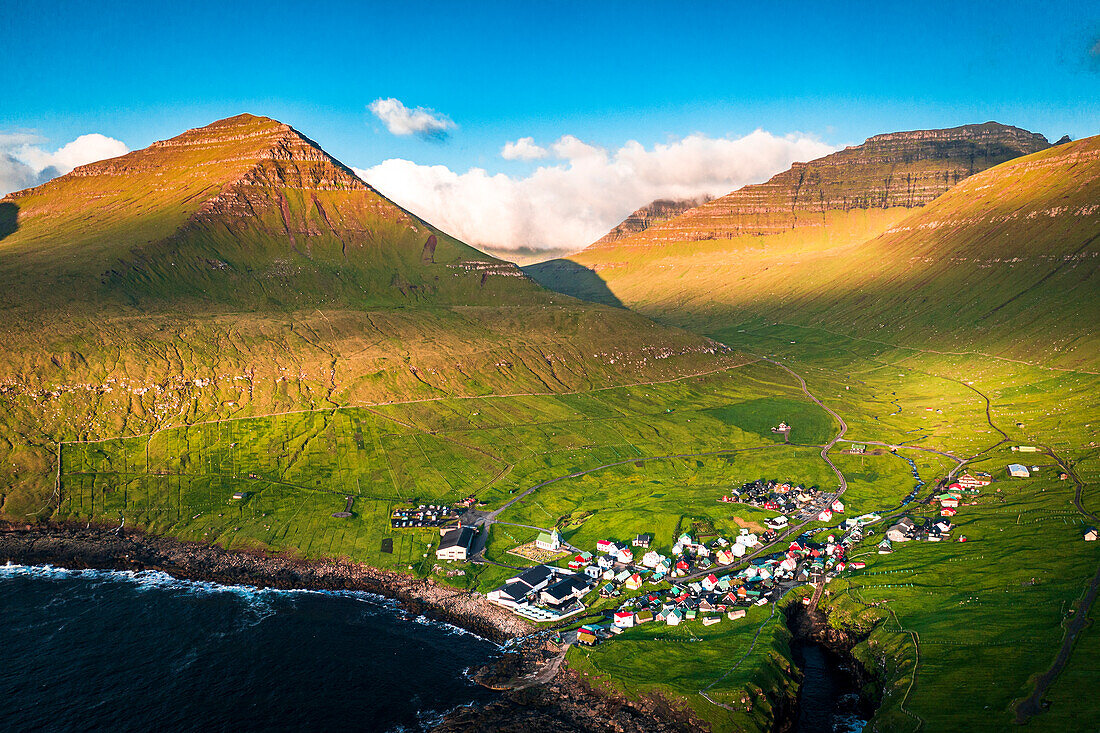 Luftaufnahme des Küstendorfes Gjogv und der Berge bei Sonnenaufgang, Eysturoy Island, Färöer Inseln, Dänemark, Europa
