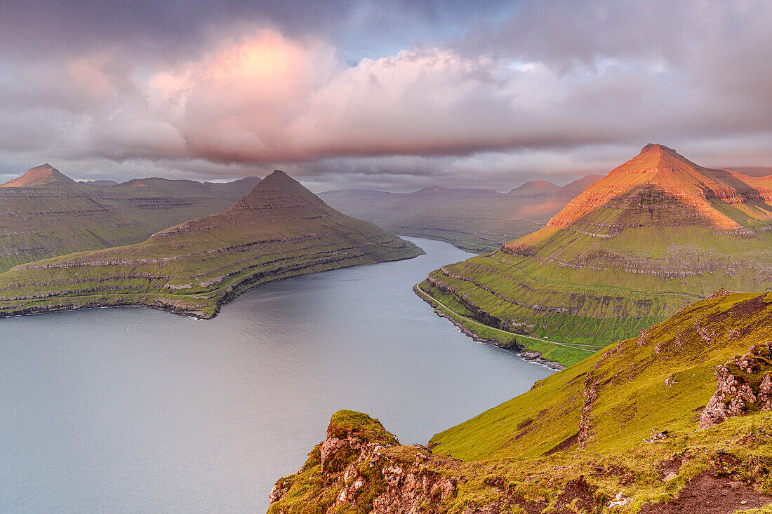 Rosafarbener Sonnenaufgang über Bergen und Klippen am Funningur Fjord, Eysturoy Insel, Färöer Inseln, Dänemark, Europa